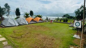 Un campamento con tiendas de campaña, un objetivo y vistas al lago.