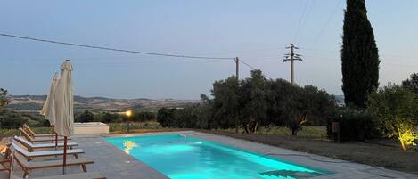 Een seizoensgebonden buitenzwembad en parasols bij het zwembad