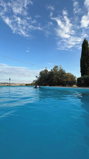 Een seizoensgebonden buitenzwembad en parasols bij het zwembad