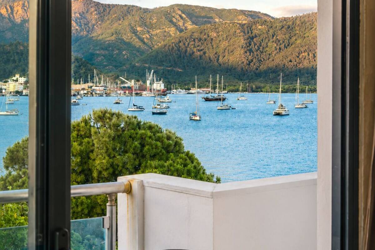 Ein Balkon mit Blick auf einen Yachthafen und Berge.