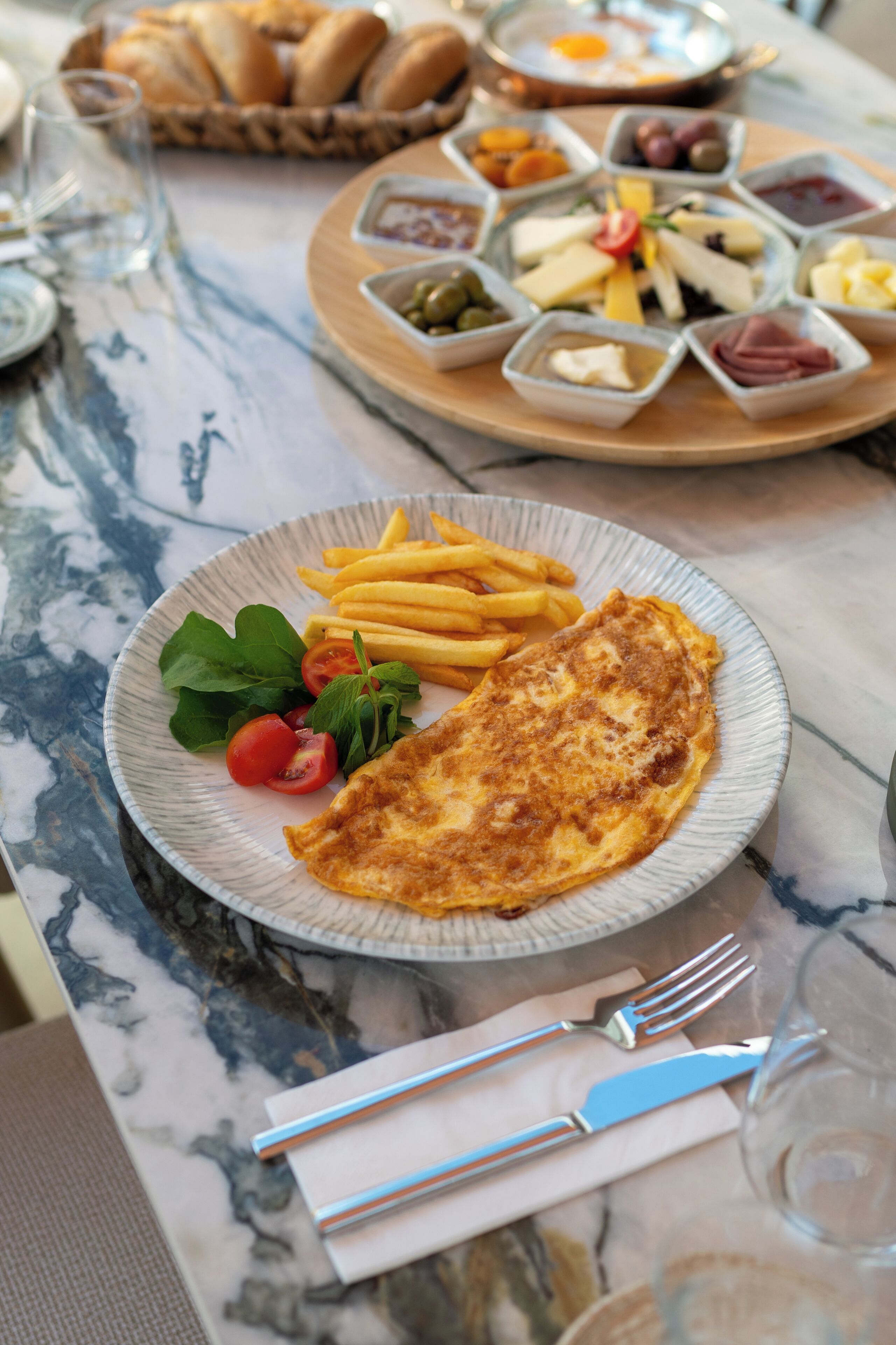 A dining table with a plate of food, including a fried egg, fries, and greens.