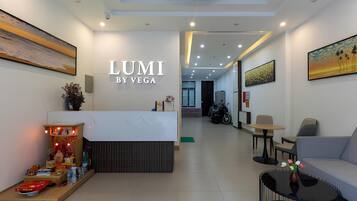 A modern reception area with a reception desk, seating area, and artwork on the walls.