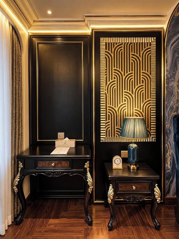A room with a dark wooden desk, a decorative lamp, and a patterned wall.