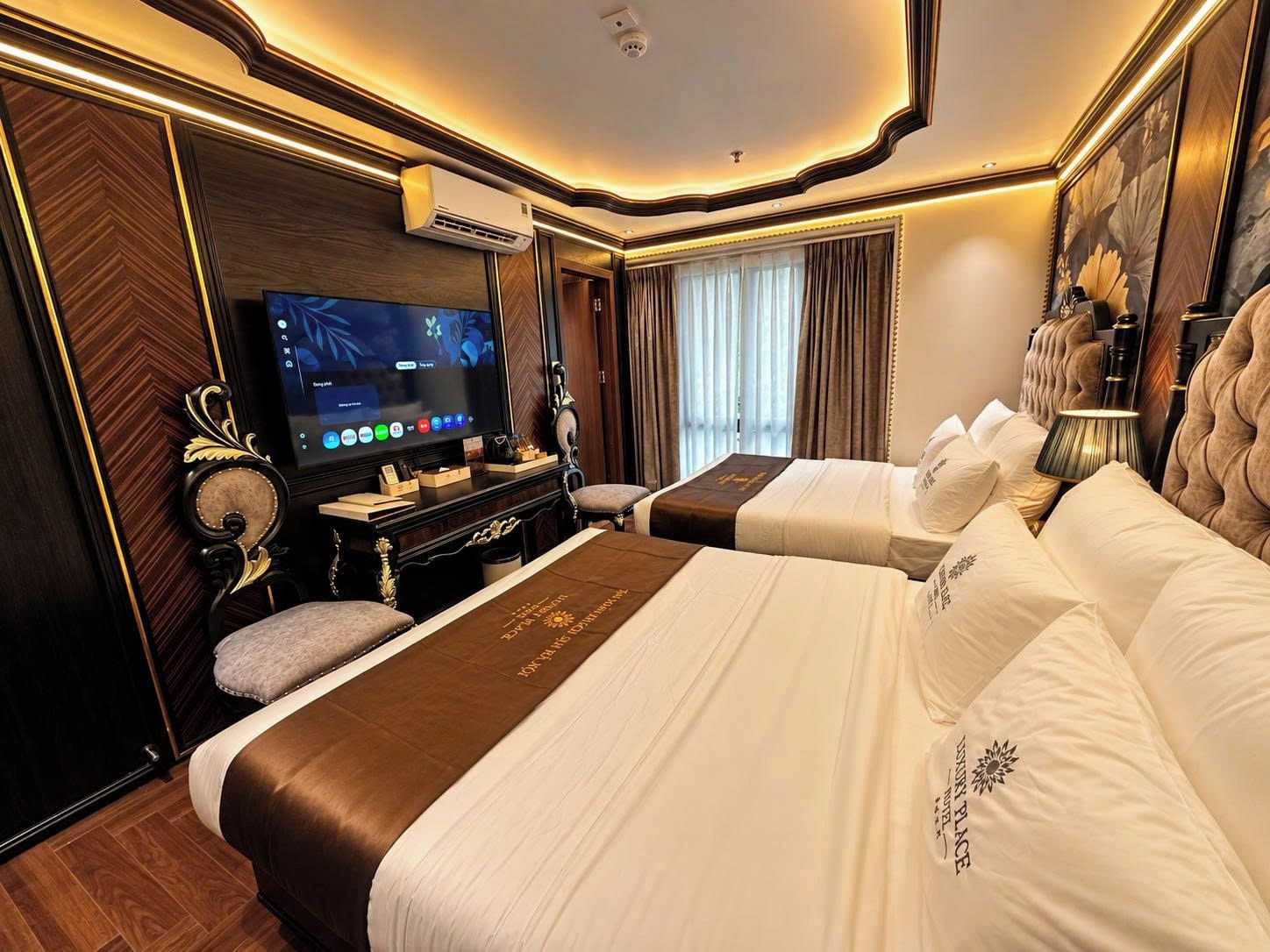 Una habitación de hotel con una cama grande, televisión y un escritorio con computadora.