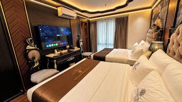 Una habitación de hotel con una cama grande, televisión y un escritorio con computadora.