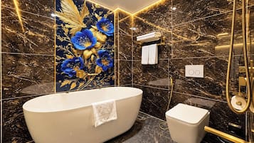 Un baño moderno con una bañera independiente, un inodoro y una zona de ducha.
