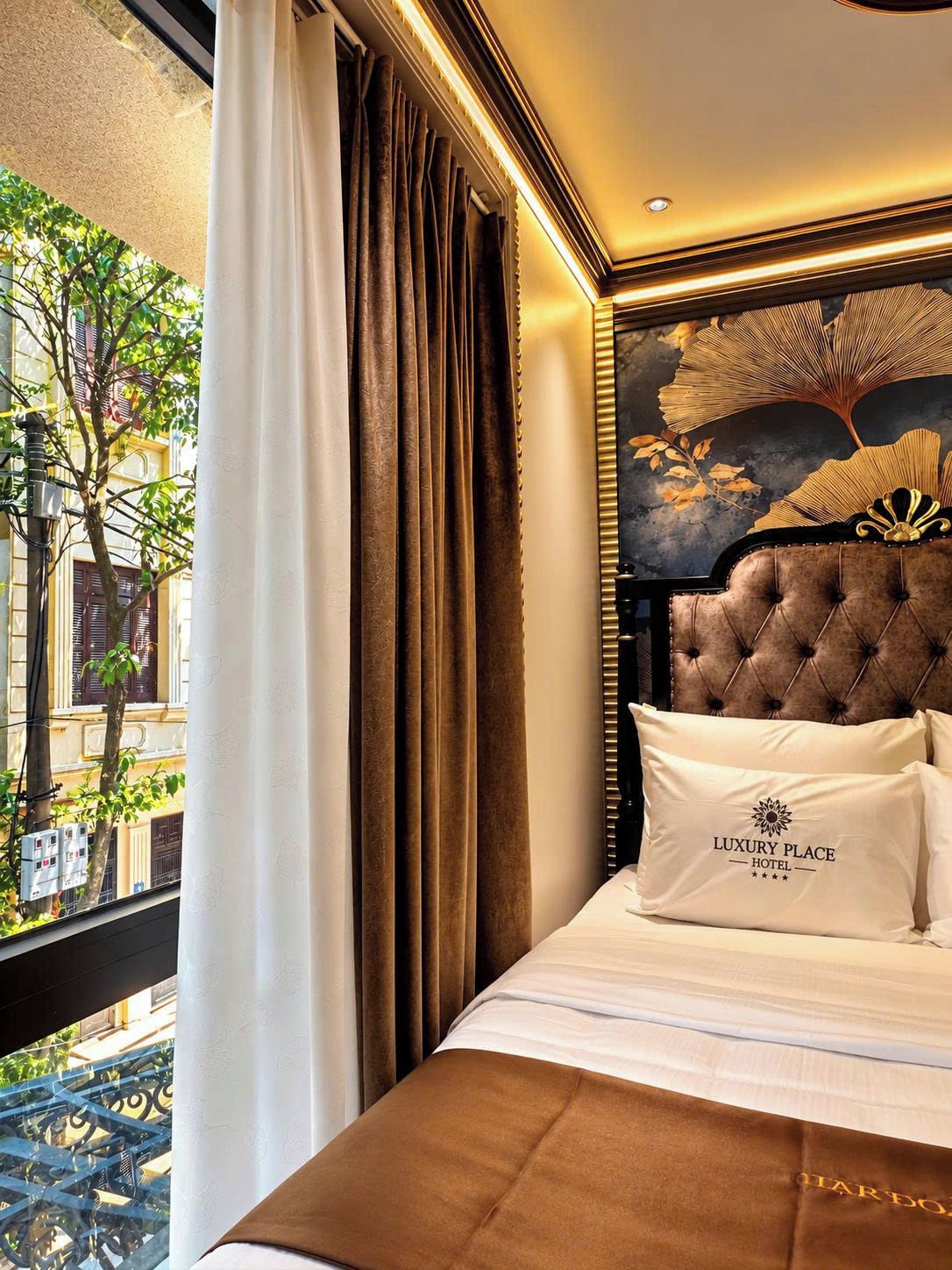 Ein Hotelzimmer mit einem großen Bett, Blick auf die Stadt und einem dekorativen Kopfteil.
