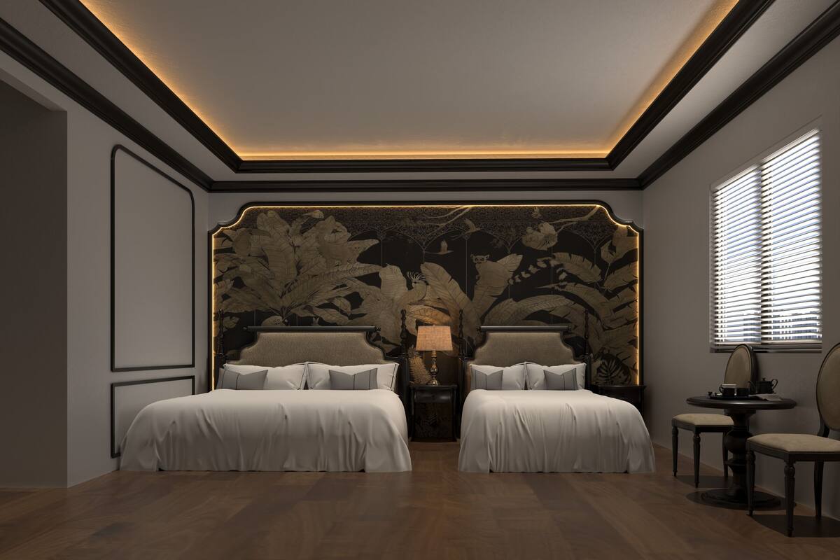 Ein Schlafzimmer mit zwei Betten, einem Nachttisch mit Lampe, einem kleinen Tisch mit Stühlen und einer großen Wanddeko.