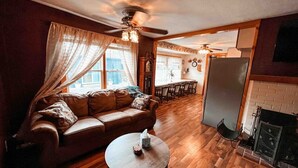 A cozy living room with a brown leather sofa, a round coffee table, and a fireplace. - 3 bd/ 10 min to dwtwn/Washer-Dryer (Indianapolis)