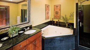 Un baño con una bañera grande, dos lavamanos, un espejo y una ducha.