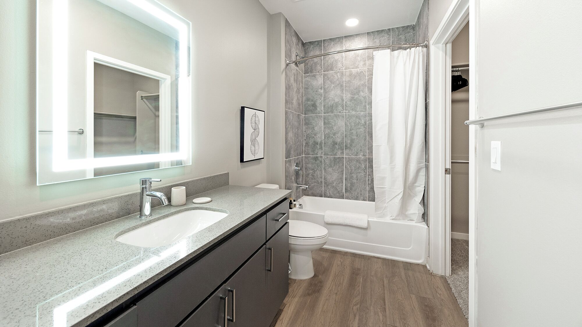 Une salle de bain moderne avec un meuble-lavabo, un évier, un miroir et une douche.