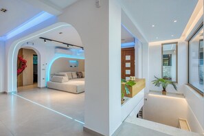 Un intérieur moderne comprenant un comptoir d’accueil, un canapé et un escalier.