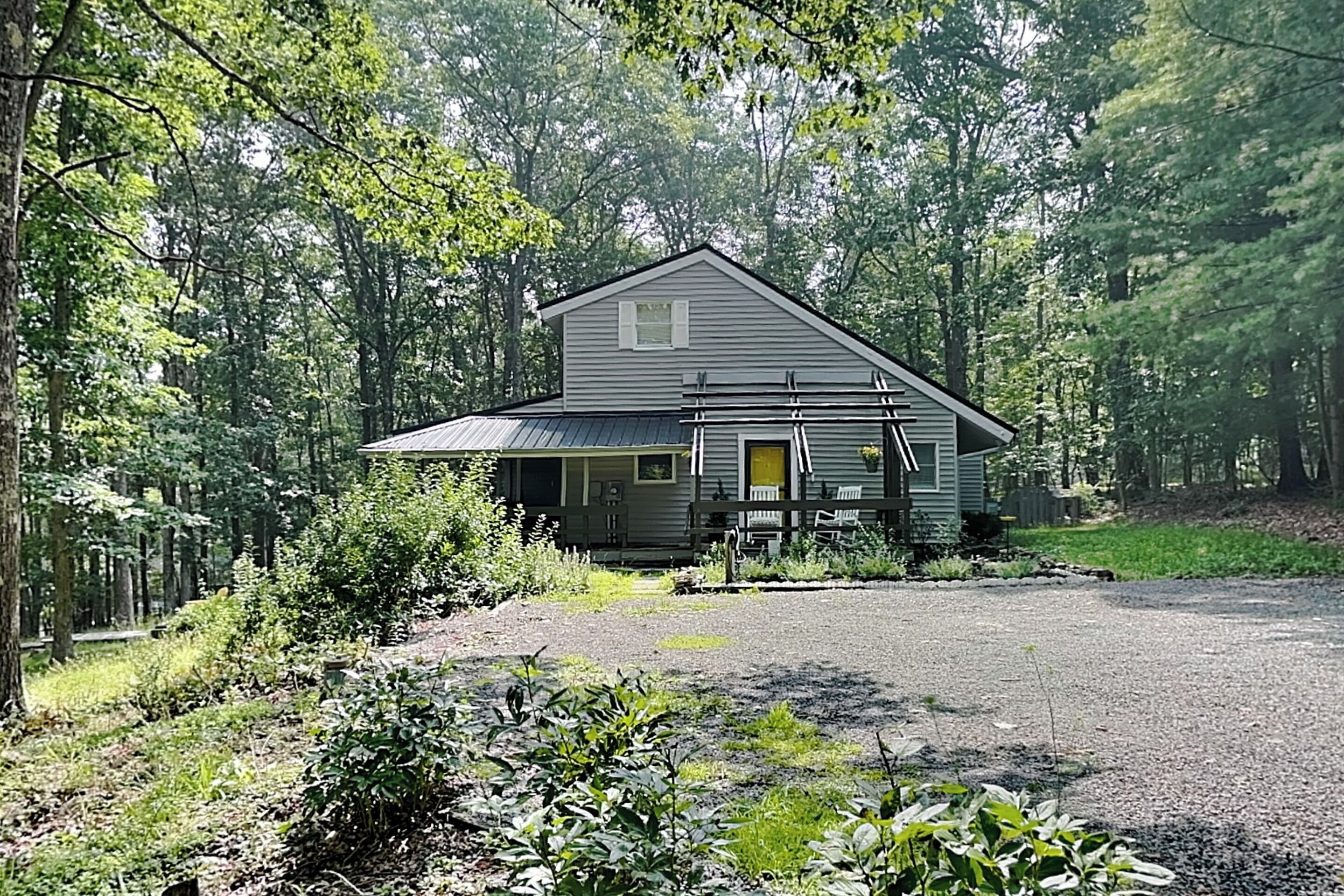 A two-story house with a front porch and a driveway.