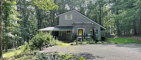 A two-story house with a front porch and a driveway.