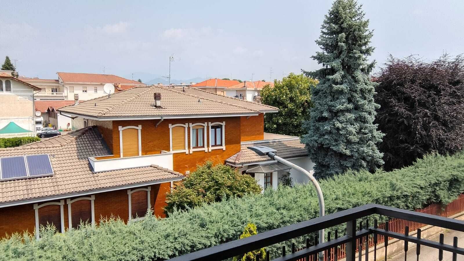 Un edificio residenziale con tetto in tegole, pannelli solari e un balcone.