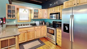 Una cucina moderna con mobili in legno, elettrodomestici in acciaio inossidabile e soffitto nero.