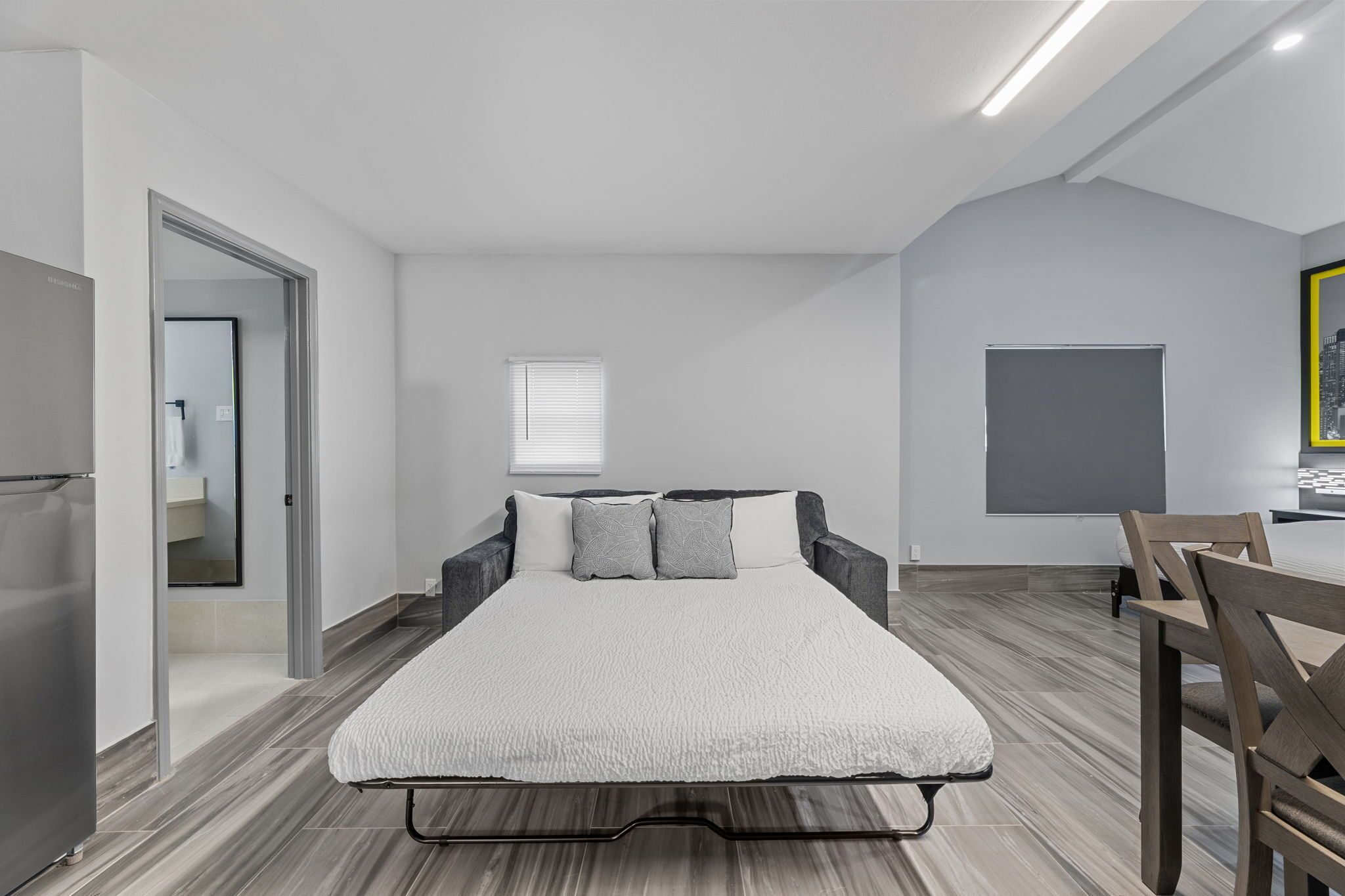 A modern bedroom with a bed, a desk, and a chair.