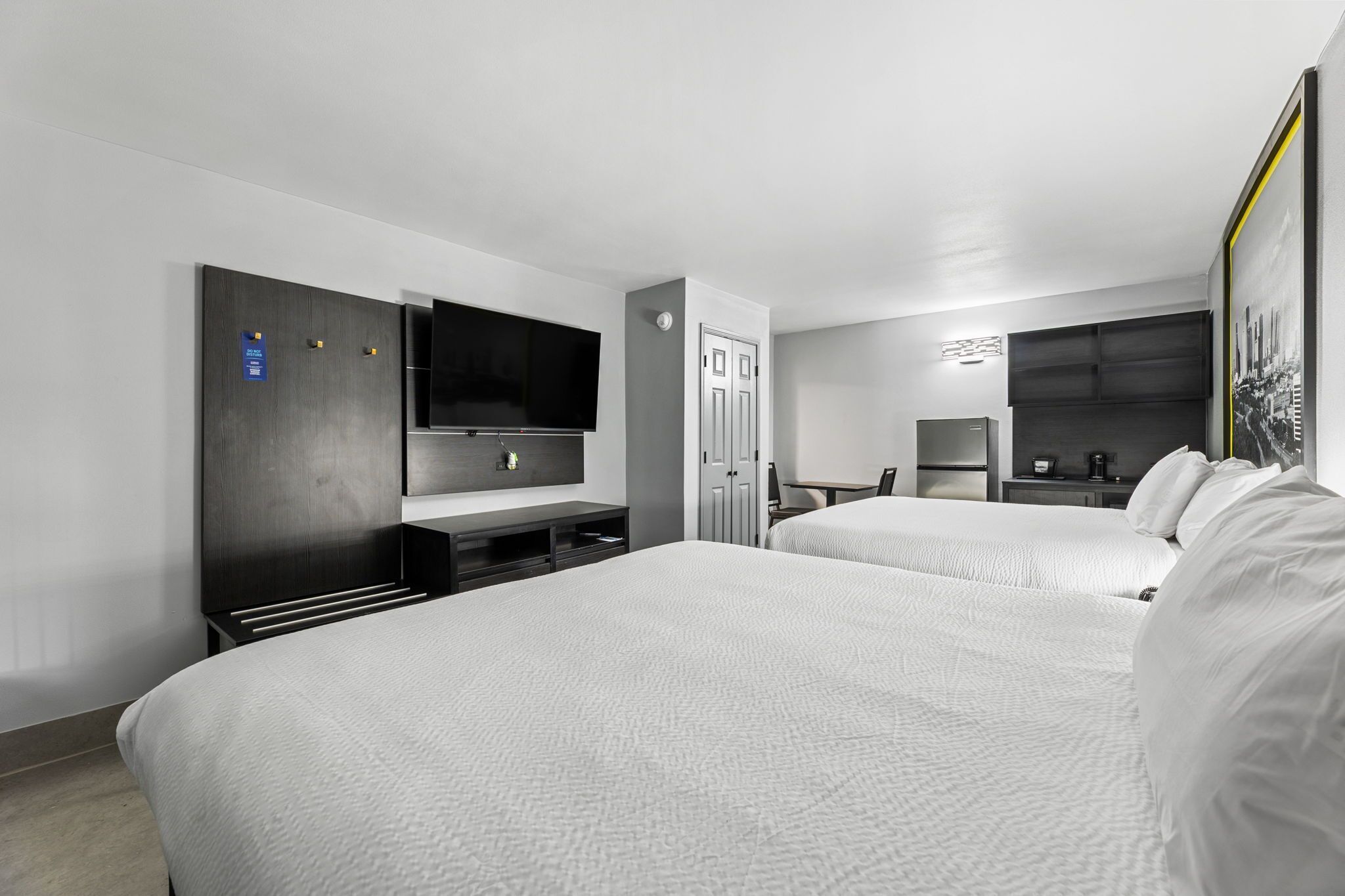 Une chambre d’hôtel avec deux lits, une télévision, un bureau et une armoire.