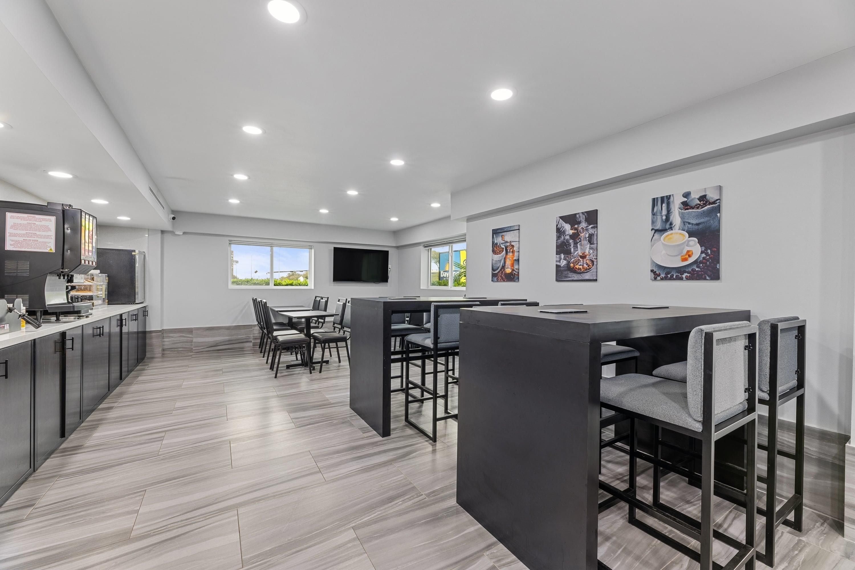 A modern kitchen with a built-in oven, a coffee machine, and a large window.