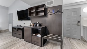 A modern bedroom with a built-in wardrobe, a flat-screen TV, and a coat rack. - Super 8 by Wyndham Texas City/Galveston Area (Texas City)