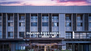 A modern hotel facade with a clear sign reading "DaysInn" and "BY WYNDHAM".