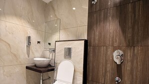A modern bathroom with a toilet, sink, and shower.