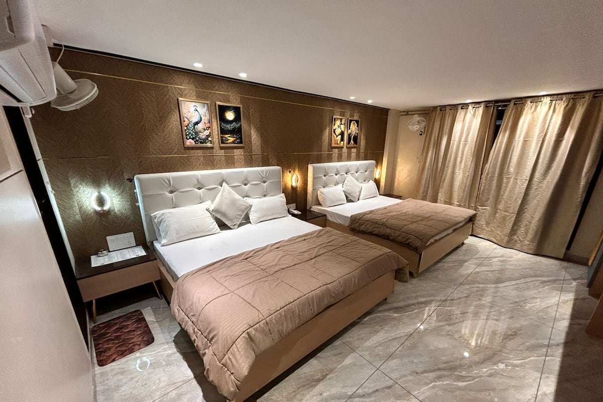Ein Hotelzimmer mit zwei Betten, einem Marmorboden und Kunstwerken an den Wänden.