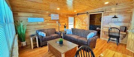 A cozy wooden interior with two sofas, a coffee table, and a chair.