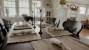 A dining table set with placemats, folded napkins, and glassware.
