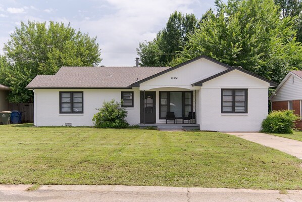 A single-story house with a front porch, a garage, and a well-maintained lawn.