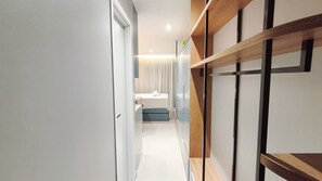 A modern hallway leading to a bathroom with a shower, a sink, and a towel. - Maré Alta Beach Hall-Praia de Tamandaré (Tamandaré)