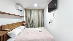 A hotel room with a bed, a TV, an air conditioning unit, and a power outlet on the wall. - Maré Alta Beach Hall-Praia de Tamandaré (Tamandaré)