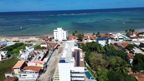 A coastal town with a prominent white building, a beach, and a clear view of the ocean. - Maré Alta Beach Hall-Praia de Tamandaré (Tamandaré)