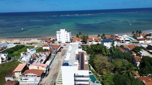 A coastal town with a prominent white building, a beach, and a clear view of the ocean. - Maré Alta Beach Hall-Praia de Tamandaré (Tamandaré)