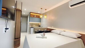 Ein Hotelzimmer mit Bett, Schreibtisch, Spiegel und Fernseher.