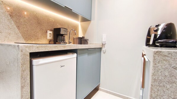 A modern kitchen with a built-in dishwasher, a coffee maker, and a phone on the counter. - Maré Alta Beach Hall-Praia de Tamandaré (Tamandaré)