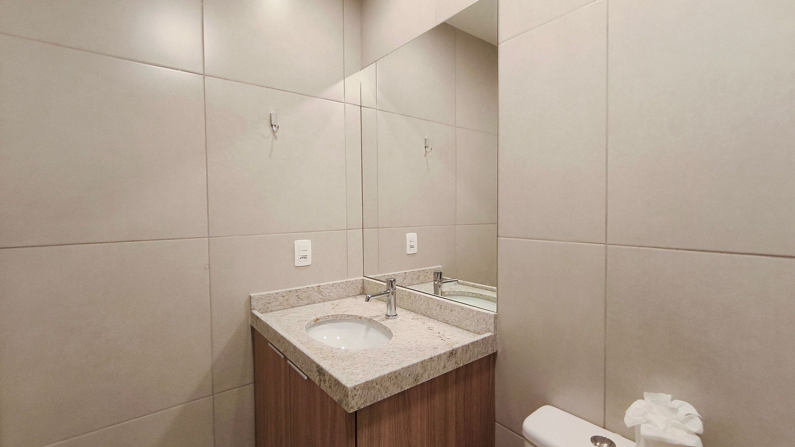 Une salle de bain avec un lavabo, un miroir et des toilettes.