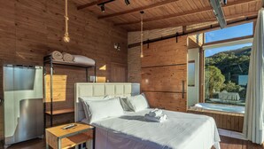 A modern bedroom with a bed, bedside table, and a built-in refrigerator. - Chalet in Mountains With Magnificent Views Vst017 (Anitapolis)