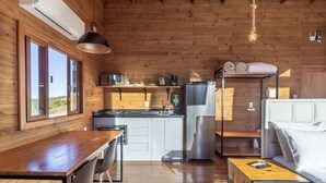 A compact kitchen with a wooden interior, a dining table, and a hanging light fixture. - Chalet in Mountains With Magnificent Views Vst017 (Anitapolis)