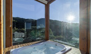 A hot tub with a wooden deck and a glass enclosure, offering a view of a mountainous landscape. - Chalet in Mountains With Magnificent Views Vst017 (Anitapolis)