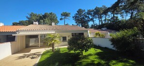 Ein Haus mit Ziegeldach, überdachter Terrasse und gepflegtem Rasen.