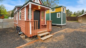 A small, single-story house with a porch and a front door. - Tiny Home 8- Mount Ethel (Bellvue)
