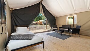 Een tent met een bed, een tafeltje en een stoel.