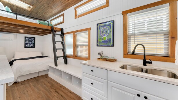 A compact bedroom with a bunk bed, a small kitchenette, and a window with blinds. - Tiny 2- Sleeping Elephant (Bellvue)