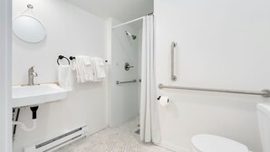 Ein modernes Badezimmer mit Waschbecken, Toilette und Duschbereich in Weiß.