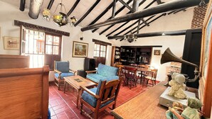 A traditional room with wooden furniture, a fireplace, and a bookshelf.