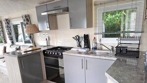 Una cocina moderna con gabinetes grises, una estufa de acero inoxidable y una encimera de madera.