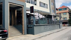 Un edificio moderno con un cartel que indica 'Armose Restaurant' y 'Ducassi Suites'.