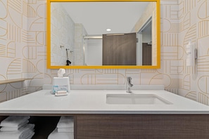 A bathroom with a large mirror, a sink, a towel rack, and a toilet. - Home2 Suites By Hilton Lebanon (Lebanon)