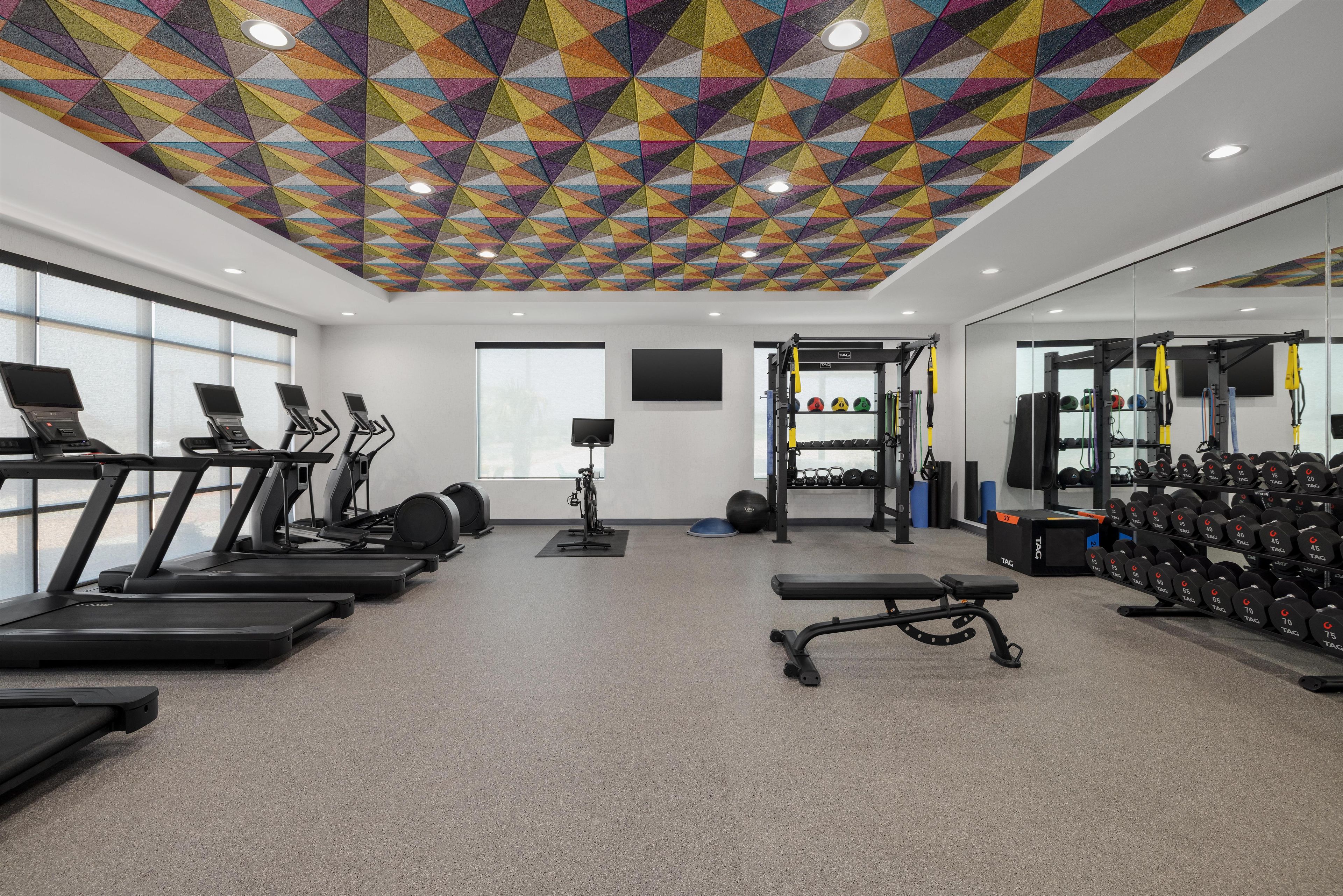 A gym with treadmills, a stationary bike, and weightlifting equipment.